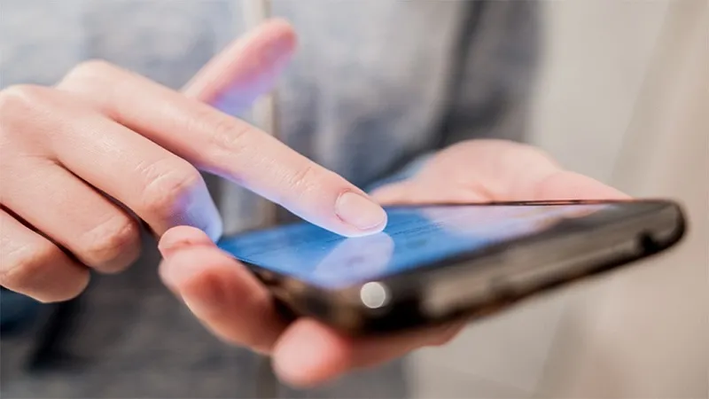 Người dùng sử dụng điện thoại di động, minh họa nhu cầu internet cấp thiết hàng ngày